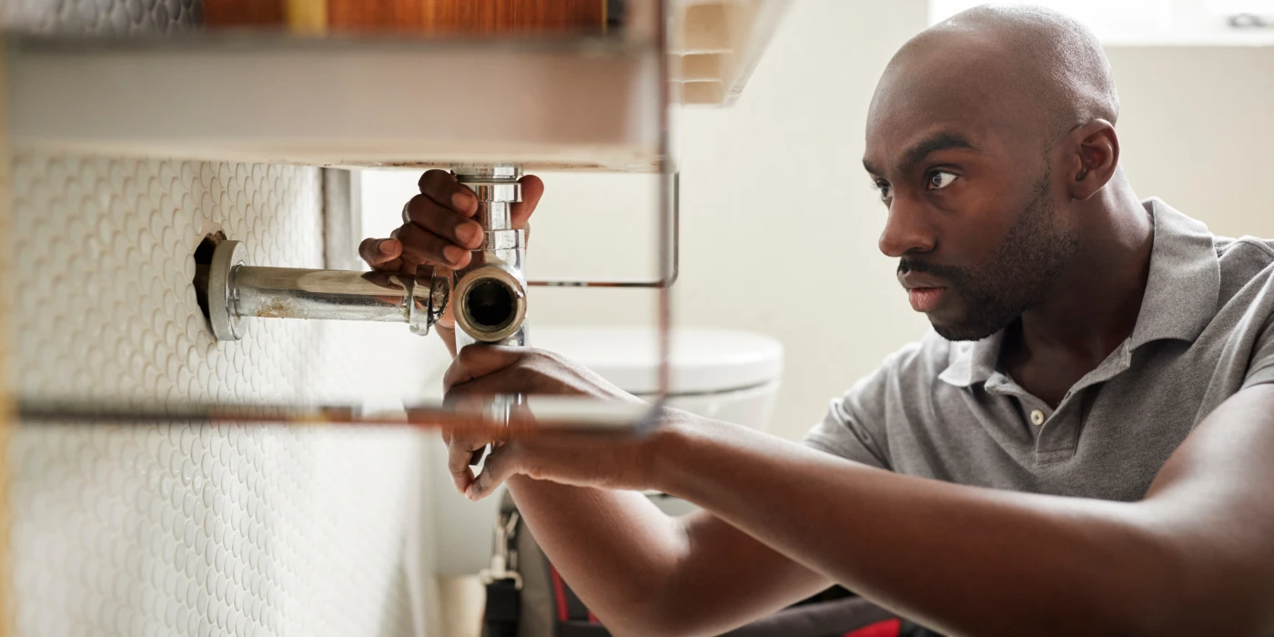 a male plumber fixing a pipe connection from TMK Plumber Austin in Austin, TX Plumber near me a male plumber fixing a pipe connection from TMK Plumber Austin in Austin, TX Plumber near me